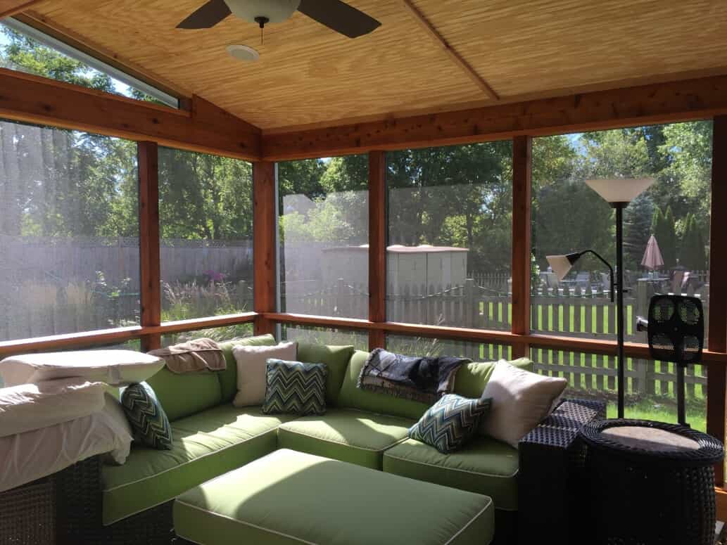 Inside of a screened porch with green lounge furniture in Wheaton ,IL.